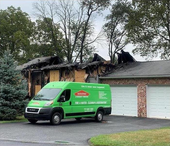 SERVPRO van parked in front of a house with a burnt roof